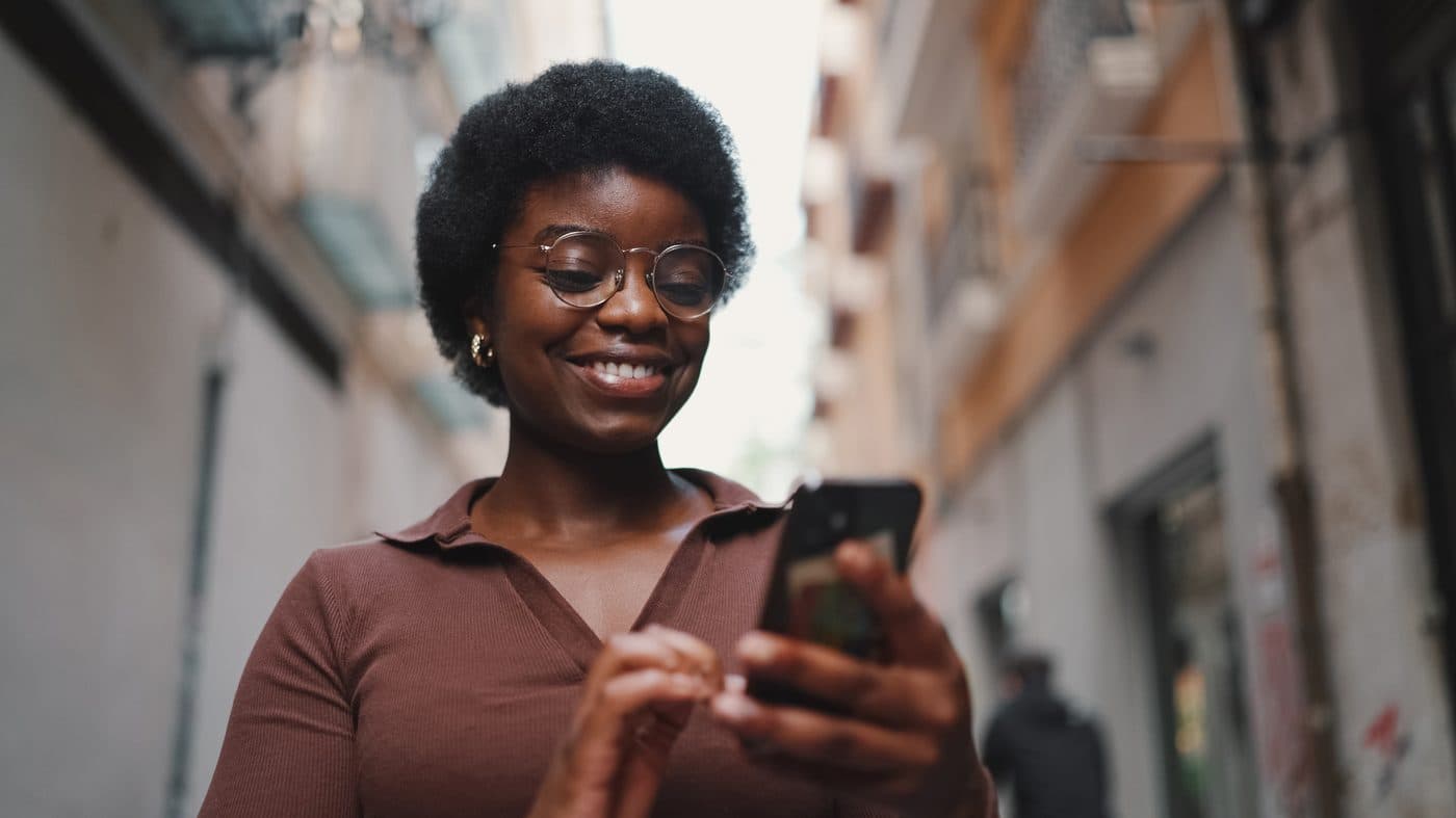 Woman smiling while checking her Dolo app on her phone